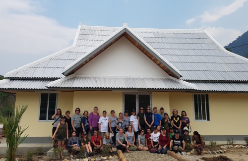 Amy and team standing in front of the new vet hospital at the opening ceremony